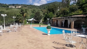 Una piscina al aire libre de temporada, sombrillas, tumbonas