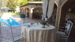 An outdoor dining area with a round table set for two, surrounded by white metal chairs. - B&B La Mimosa (Cava de' Tirreni)