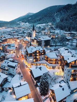 Un pueblo cubierto de nieve con varios edificios, incluyendo una iglesia destacada con un campanario alto.