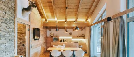 Una cocina moderna con vigas de madera, pared de piedra y cabeza de ciervo montada.