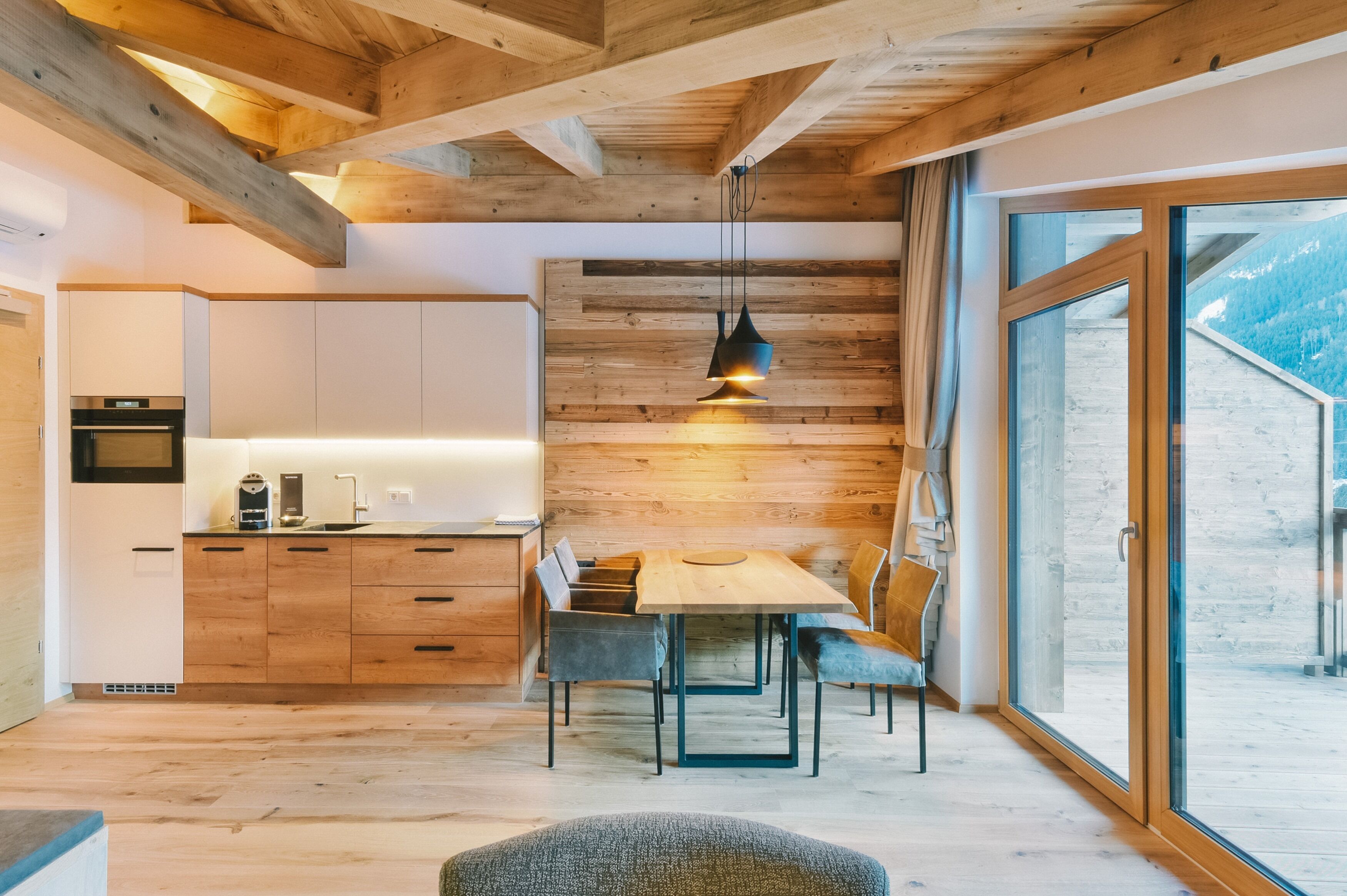 A modern kitchen with wooden cabinetry and a dining area with a table and chairs.