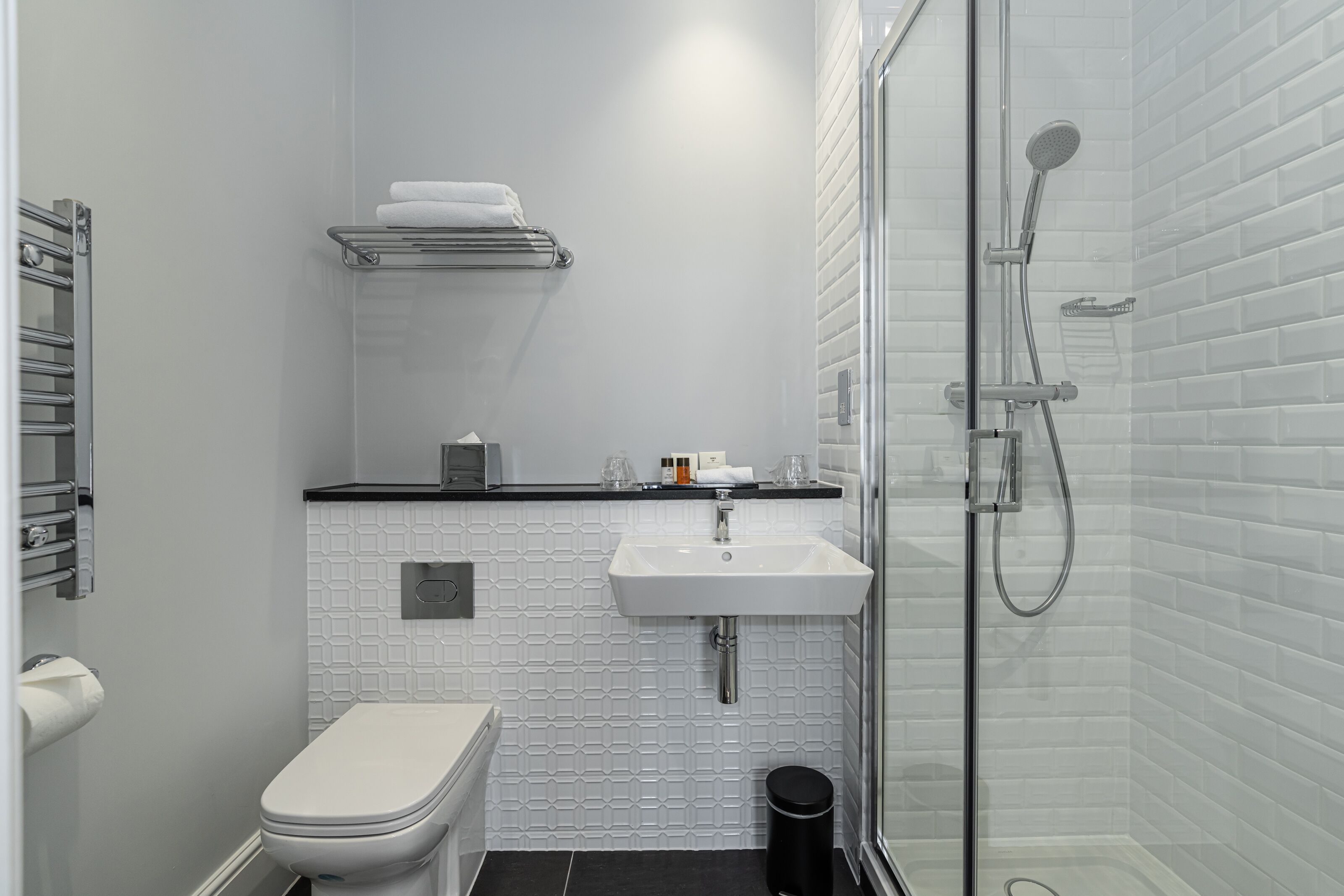 A modern bathroom with a toilet, sink, and shower.