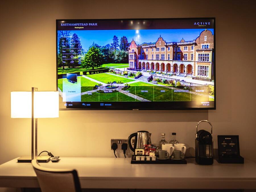 A television displaying a view of East Hampton Town Park, with a hotel information screen on the TV.