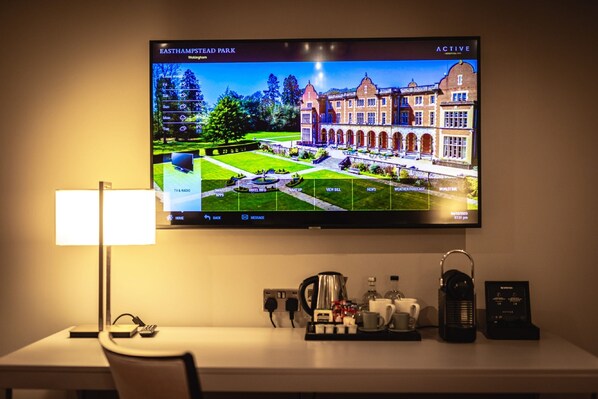 Un televisor muestra una vista del parque del pueblo de East Hampton, con una pantalla de información del hotel en la TV.