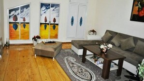 Ein Wohnzimmer mit einer Couch, einem Couchtisch, einem Schachbrett und zwei Bildern an der Wand.
