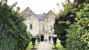 A stone building with a symmetrical facade, a central entrance, and a pathway leading to the door. - Faenol Fawr Hotel (Rhyl)