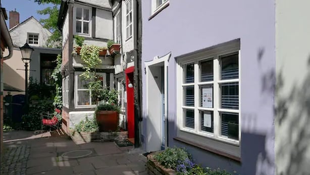 Eine enge Straße, gesäumt von Häusern mit einer Mischung aus traditioneller und moderner Architektur.