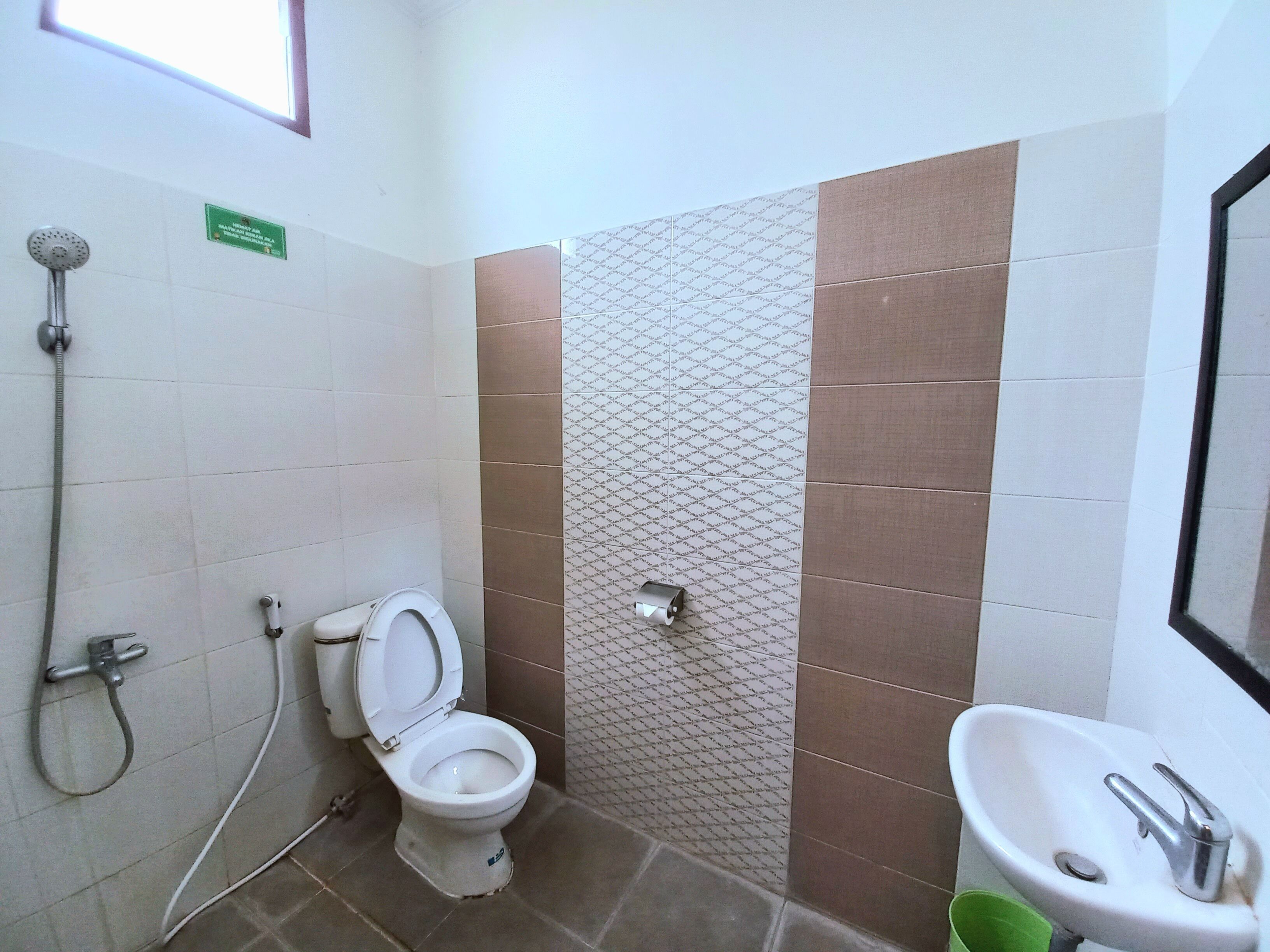 A bathroom with a toilet, a shower, and a sink.