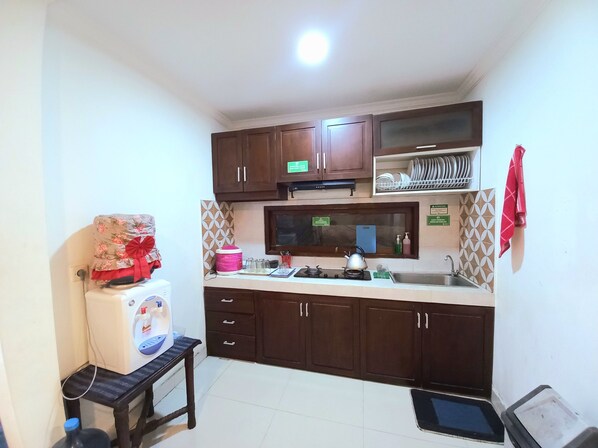 A compact kitchen with a microwave, sink, and cabinets.