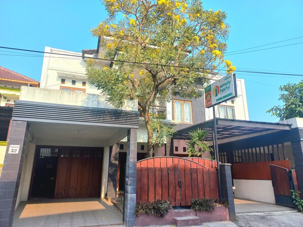 A residential building with a gated entrance, a visible number '32' sign, and a 'simply home' sign indicating a real estate agency. - Homestay Jogja dekat Malioboro by Simply Homy (Yogyakarta)