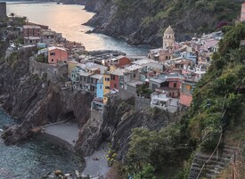 Un pueblo costero con edificios coloridos asentados sobre acantilados rocosos con vistas al mar.