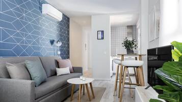 Studio (1B) | Woonruimte | Een 36-inch flatscreentelevisie met kabelzenders en een smart-tv