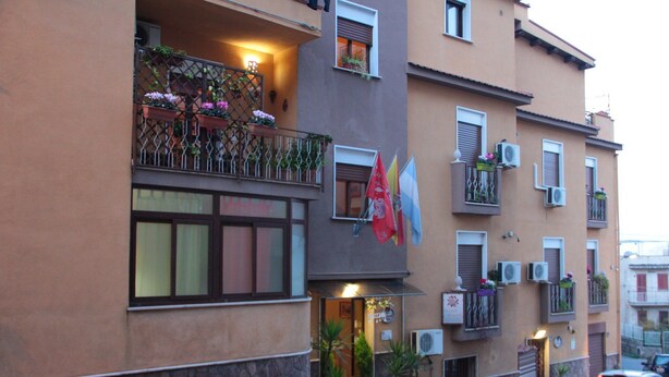 A multi-story building with balconies, air conditioning units, and potted plants. - La Casa Di Evita (Carini)