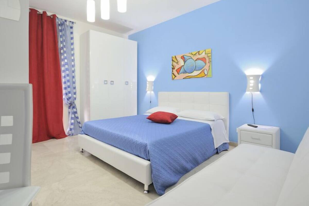 Un dormitorio con una cama individual, una mesita de noche, un armario y un cuadro en la pared.