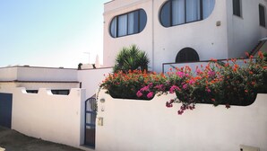 Um edifício moderno com telhado plano, janelas amplas e fachada branca.