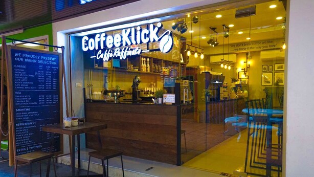 A Coffee Klink cafe with a menu board outside and a seating area inside. - Plu Garden Villa (Bangkok)
