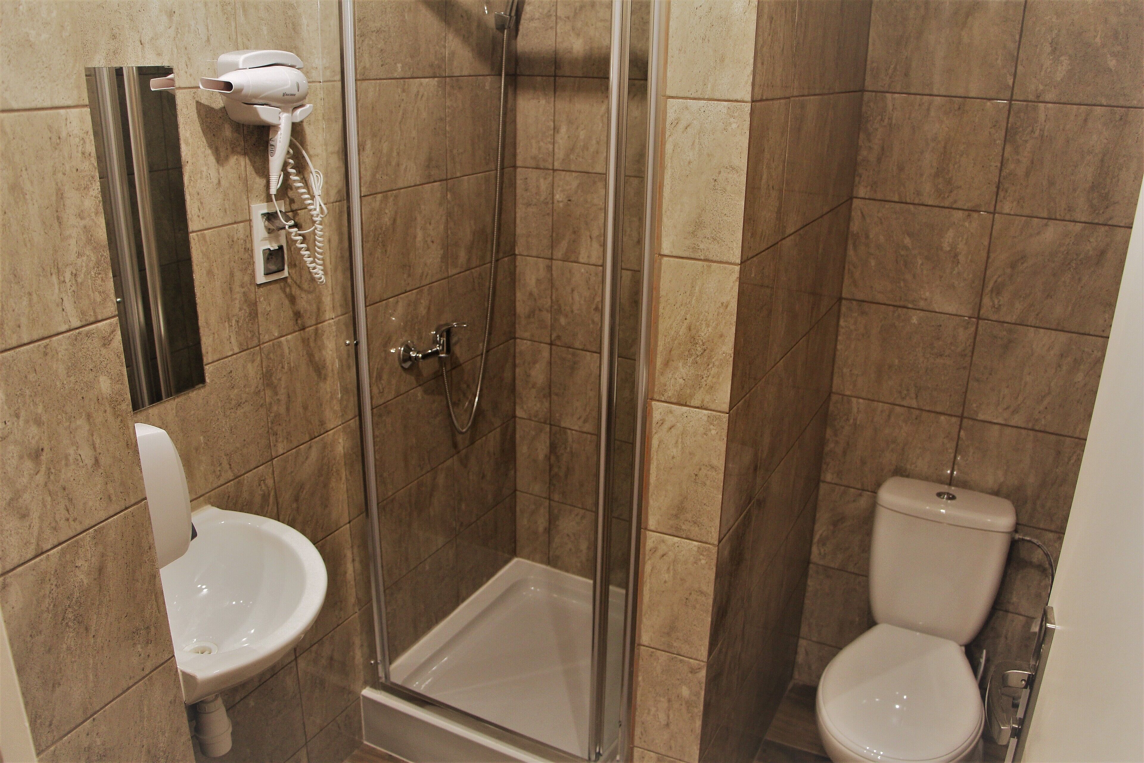 Un baño con ducha, inodoro y lavamanos.