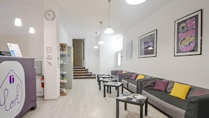 En receptionsområde med disk, siddepladser og en trappe til en anden etage.