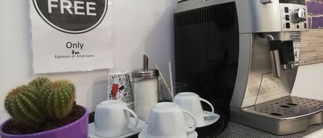 A coffee machine with cups and a promotional sign for a coffee offer.