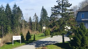 Ein Weg, der zu einem Gebäude führt, an dem ein Schild daraufhinweist, dass es sich um ein Hotel, Restaurant und Café handelt.
