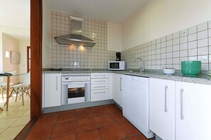 A kitchen with white cabinets, a microwave, a stove, and a dishwasher. - Villa Salobre Morro Golf 2 (Maspalomas)
