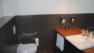 A modern bathroom with a toilet, sink, and towel rack.