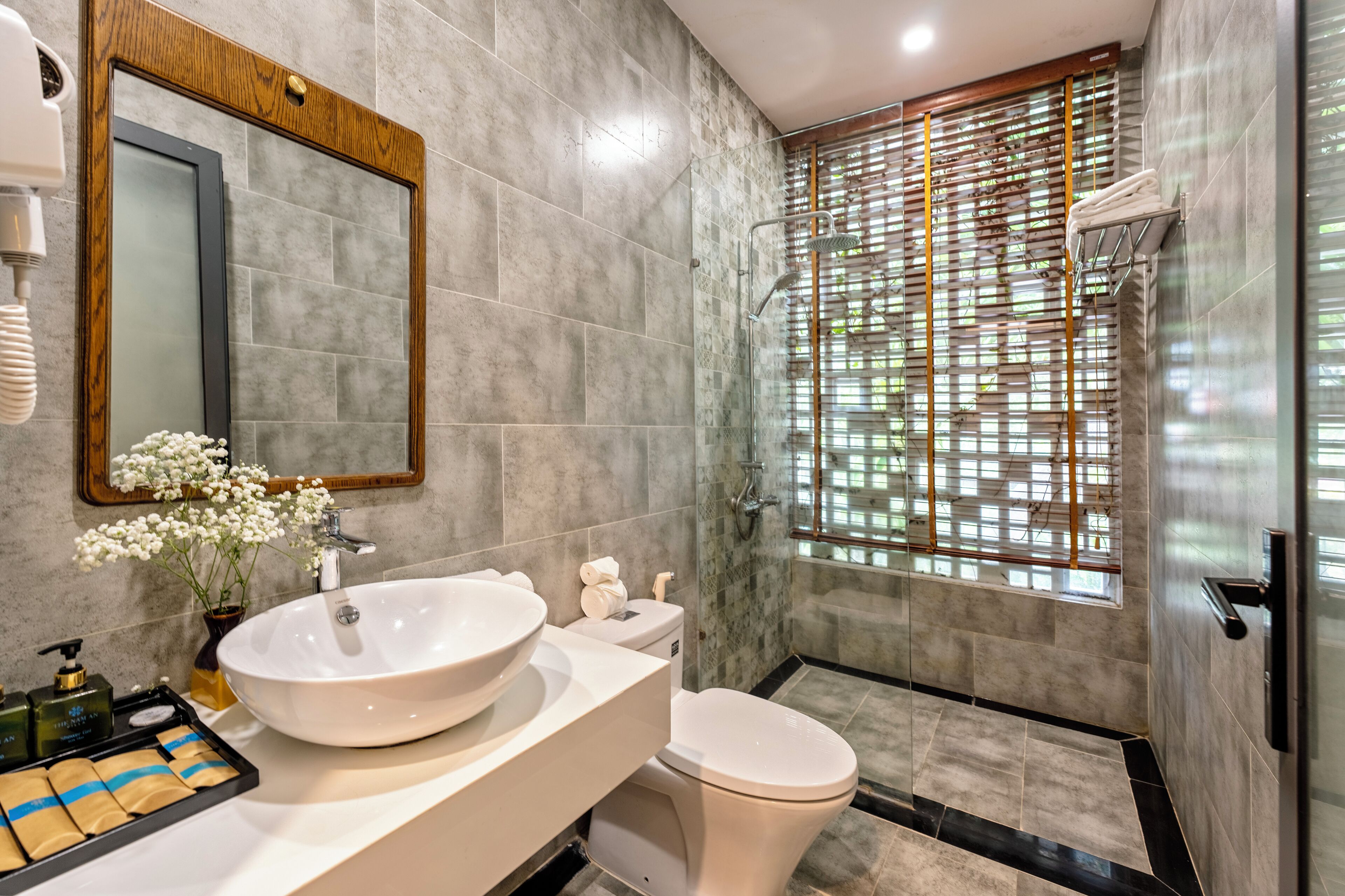 A modern bathroom with a large sink, toilet, and shower area.