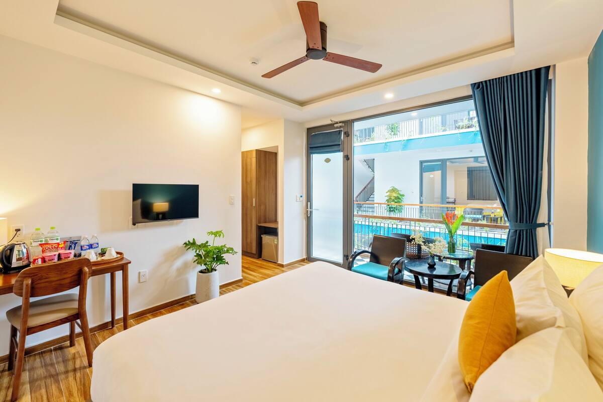 Deluxe Queen Balcony with Pool View | Allergitestet sengetøy, minibar, safe på rommet og skrivebord
