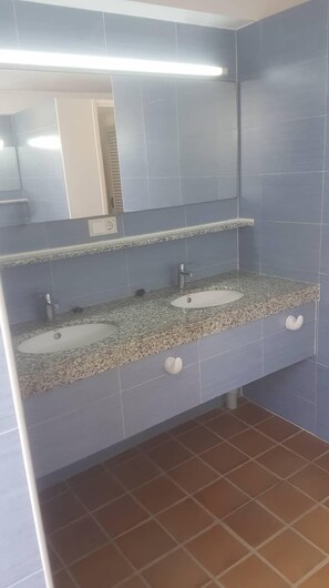 Un baño con dos lavamanos, un espejo y una lámpara.