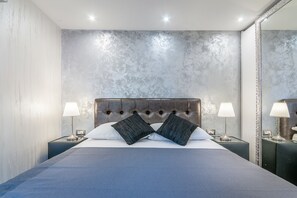 A modern bedroom with a large bed, two bedside lamps, and a large mirror. - Villa Fema (Rovinj)