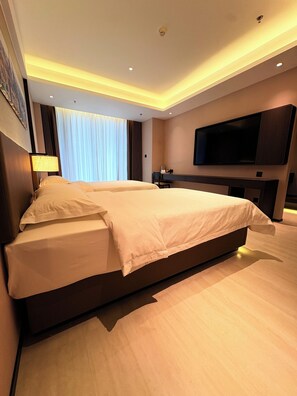A modern hotel room with a large bed, a desk, a flat-screen TV, and a large window with curtains. - Guangzhou BaiMing Hotel (Guangzhou)
