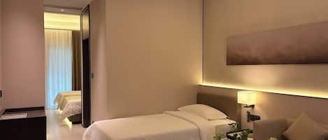 Ein Hotelzimmer mit einem Bett, einem Schreibtisch, einer Couch und einem großen Gemälde an der Wand.