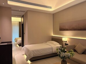 Habitación de hotel con cama, escritorio, sofá y un cuadro grande en la pared.