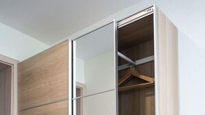 A modern wardrobe with sliding doors and a mirrored closet interior. - Hotel Haus am Berg (Pruemzurlay)