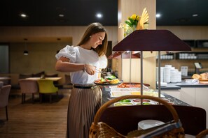 A buffet setup in a restaurant with a variety of food items on display. - Berill Suites (Sarvar)