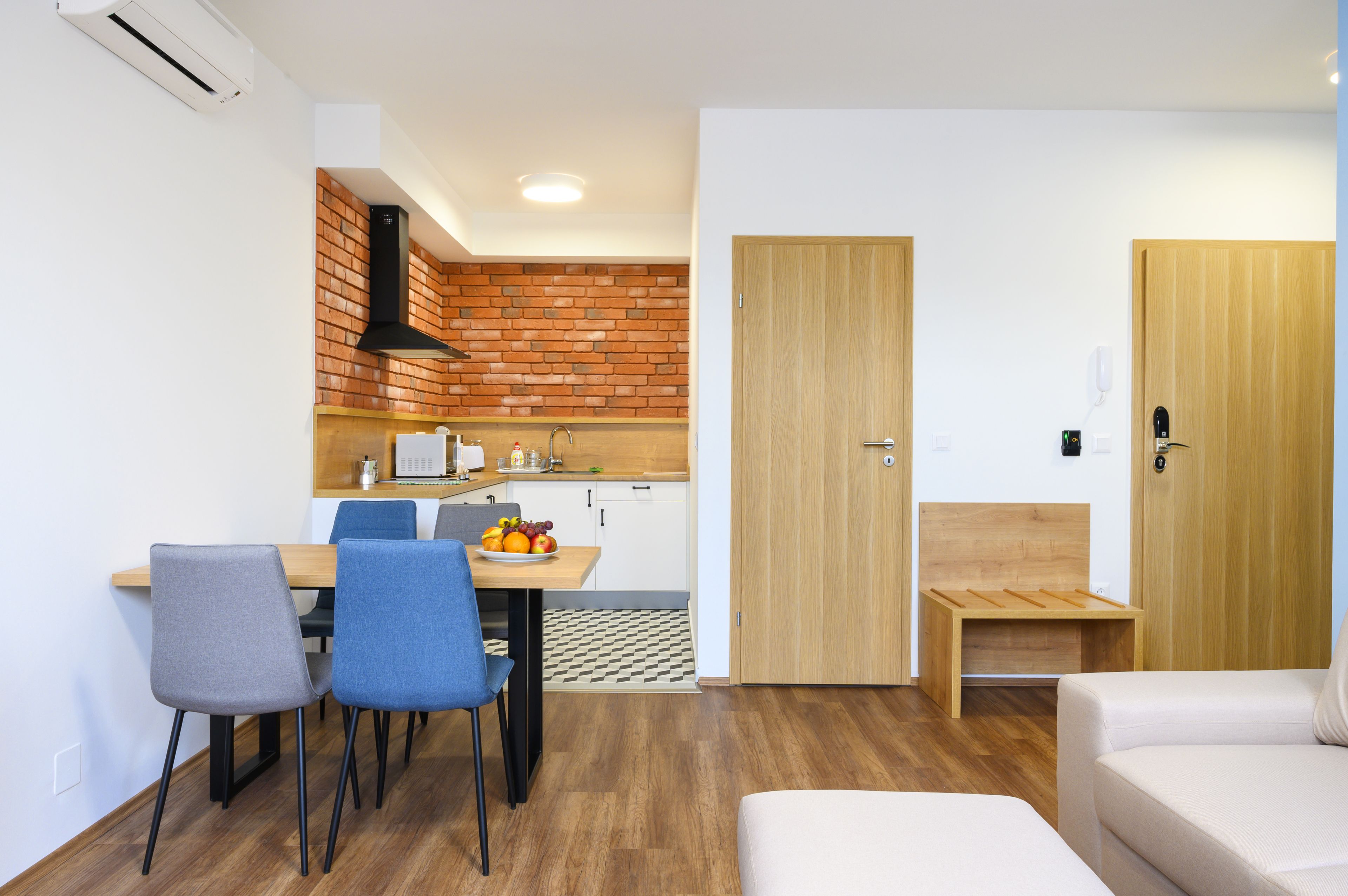Ett kompakt bostadsutrymme med en matplats, ett litet kök och en liten sittgrupp.