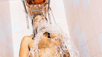 A person in a shower with water flowing over them.