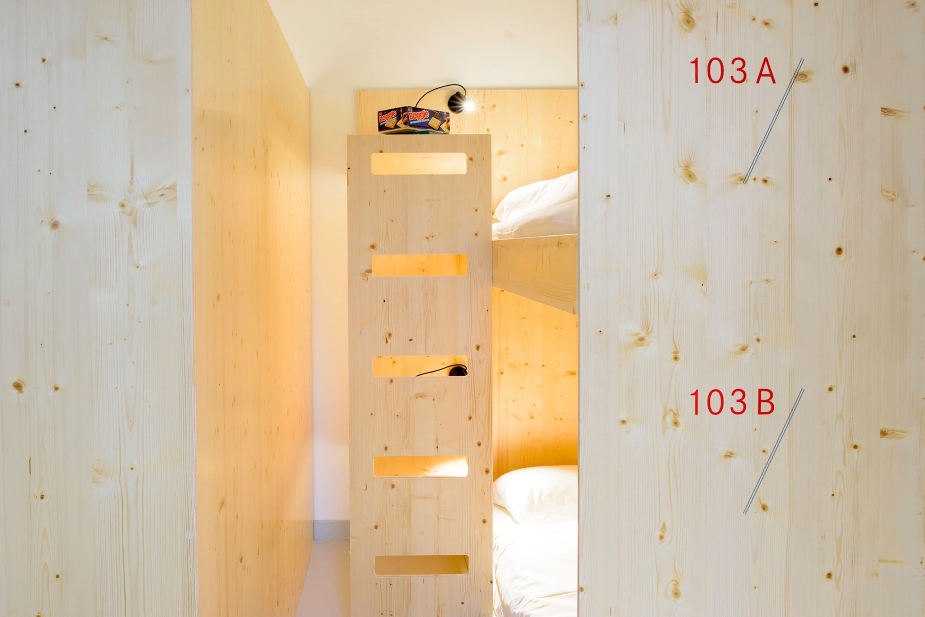A wooden room with bunk beds labeled 103A and 103B.