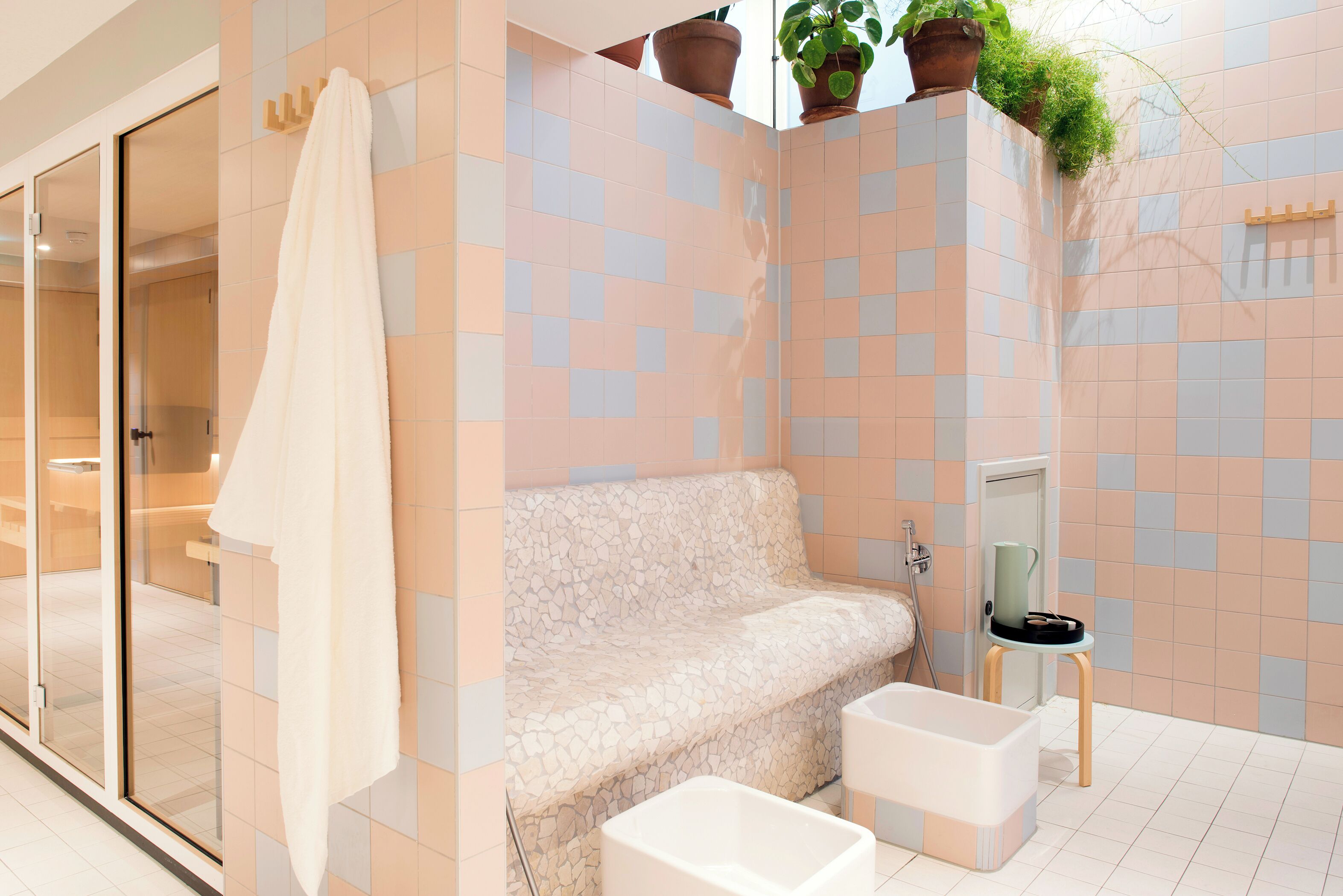 Un baño moderno con un banco de textura de piedra, una bañera y una zona de ducha.