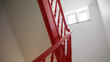 A staircase with red balusters leading to a landing.