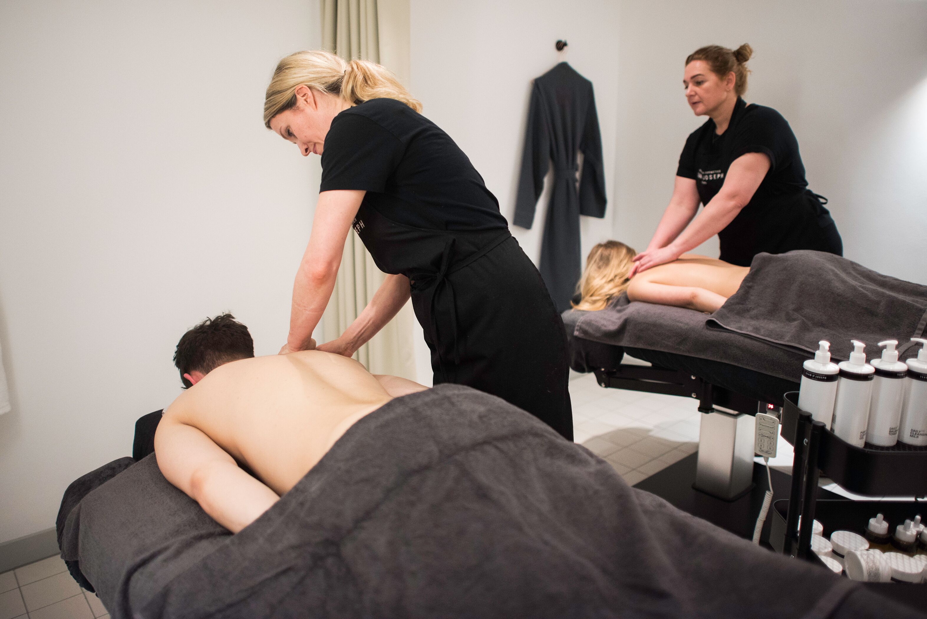 A massage therapy room with two clients receiving back massages.