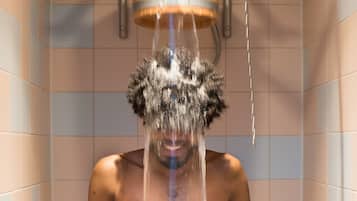 Guests can enjoy a refreshing shower experience with a water feature above.
