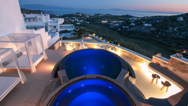 A rooftop pool with a view of a coastal town at dusk. - Sea & Stone Residence Mykonos (Mykonos)