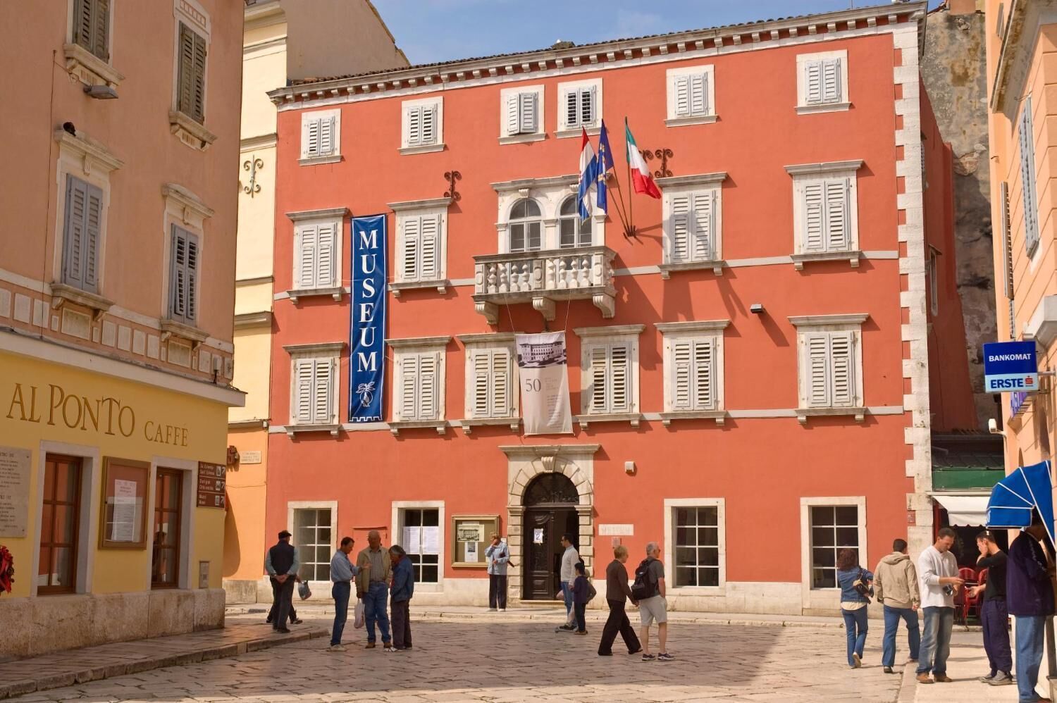 A historic building with a prominent museum sign, a traditional facade, and a cobblestone street.
