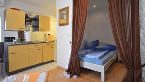 A compact room with a bed, a small kitchenette, and a bathroom. - Zdenac Studio (Rovinj)