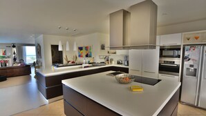 A modern kitchen with a large island, stainless steel appliances, and a view to the living area. - Super 3 Bedroom Villa With Amazing Ocean Views (Swieqi)