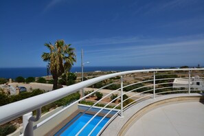 A pool area with a clear view of the ocean and a palm tree. - Super 3 Bedroom Villa With Amazing Ocean Views (Swieqi)