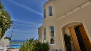 A modern building with a curved facade, large windows, and a pool area. - Super 3 Bedroom Villa With Amazing Ocean Views (Swieqi)