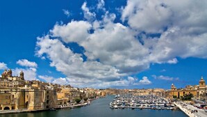 A coastal cityscape with historic buildings, a marina, and a clear sky. - Traditional Maltese Townhouse, Roof Terrace and Views (Senglea)