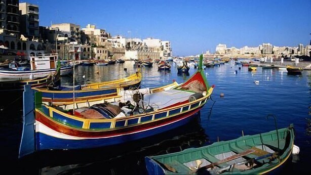 A harbor with boats docked, buildings in the background, and calm water. - Charming Seafront House In Kalkara (Kalkara)